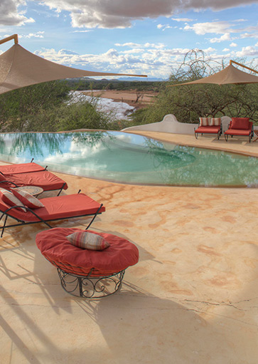 Poolside at Sasaab luxury lodge in Samburu, with red loungers